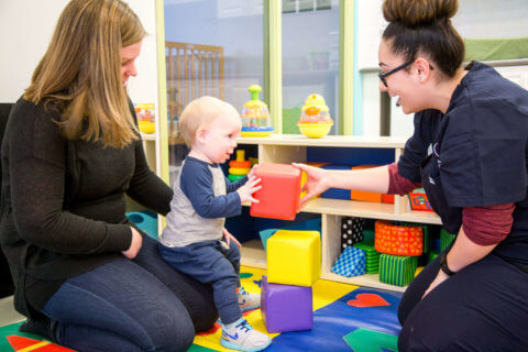 Childhood educator playing with child at daycare