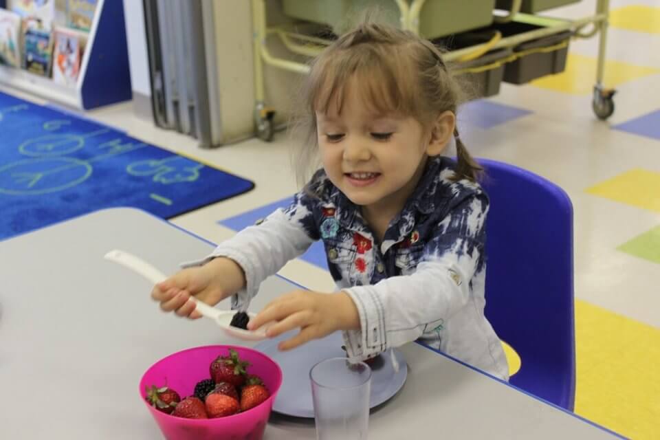 Smiling child eating berries