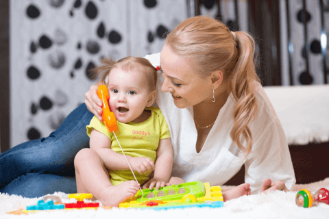 Mother playing with toys with infant child
