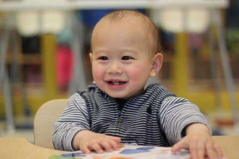 infant viewing an image book at daycare
